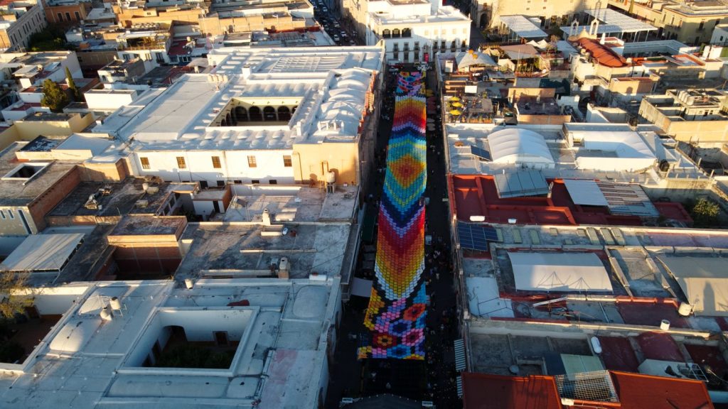 Decoración del Cielo Tejido en el Corredor Cultural Carranza, inspirada en los atardeceres de Aguascalientes y las flores del tocado de La Catrina.